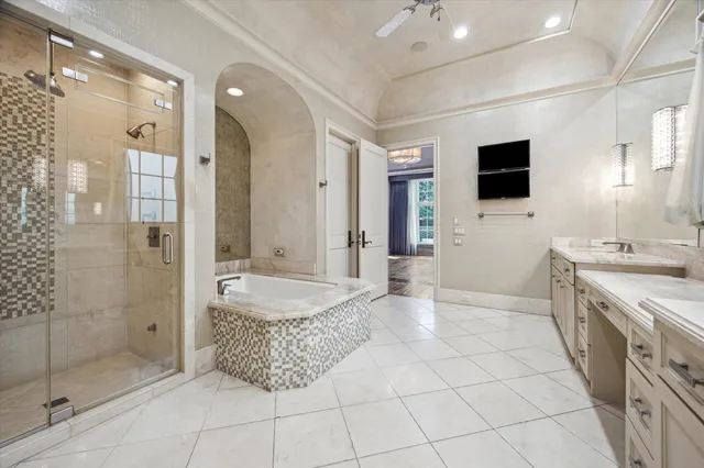 a spacious bathroom with a granite countertop sink a mirror a shower and a bathtub