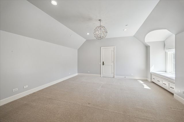 en empty room with windows and chandelier fan