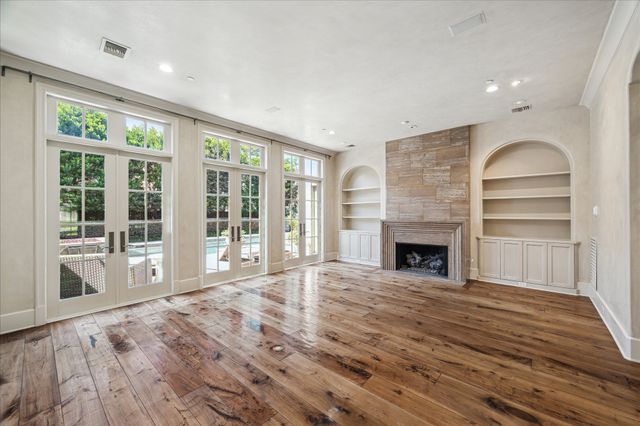 a view of an empty room with a fireplace and a window