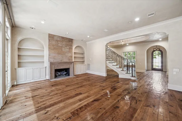 a view of an empty room with window and wooden floor