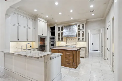 a kitchen with kitchen island granite countertop a stove a sink and a refrigerator