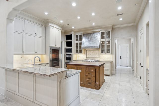 a kitchen with kitchen island granite countertop a stove a sink and a refrigerator