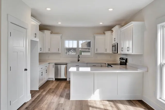 a kitchen with white cabinets appliances and a sink