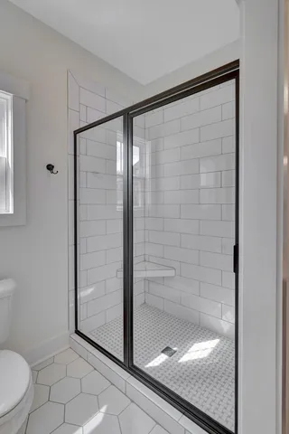 a spacious bathroom with a double vanity sink a toilet and a mirror