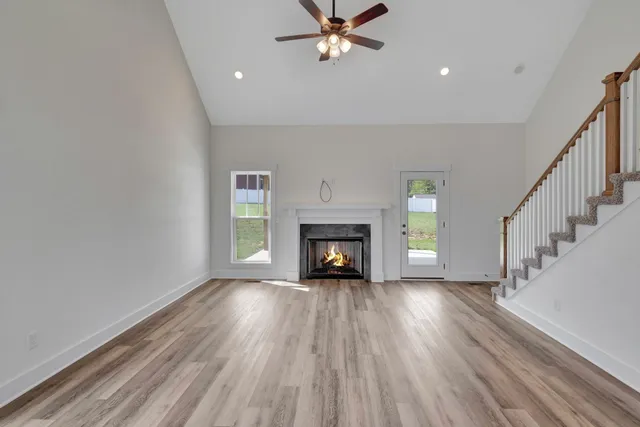 a view of an empty room with a fireplace and a window