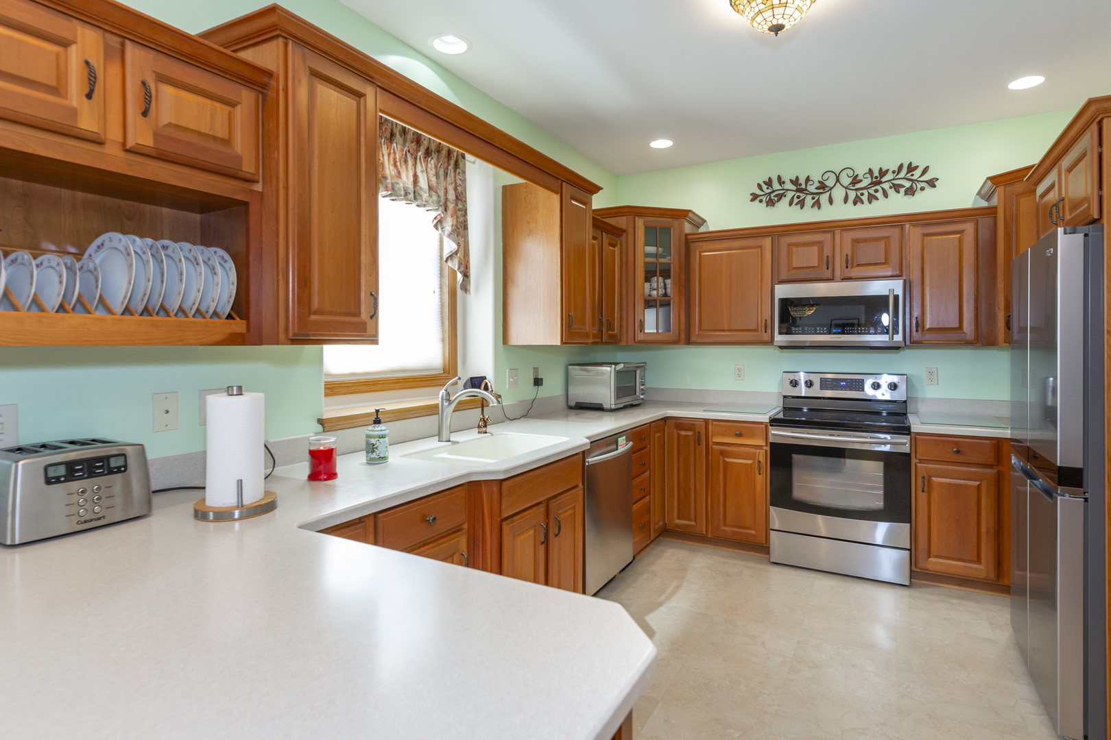 311 Stearn Drive Genoa, IL 60135 - Photo 20 of 48 a kitchen with stainless steel appliances a stove a sink a microwave a refrigerator and cabinets