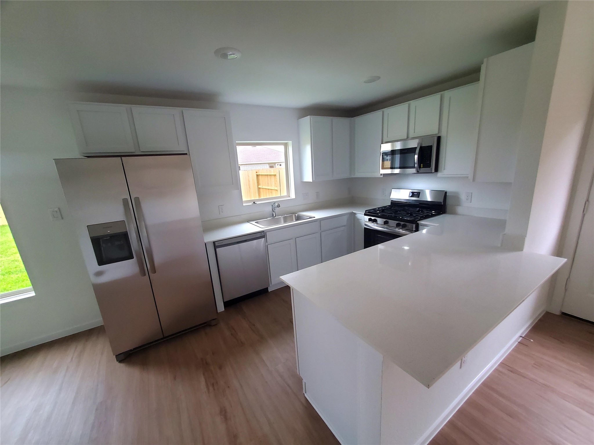 3115 Savannah Rose Drive Angleton, TX 77515 - Photo 1 of 20 a kitchen with stainless steel appliances a microwave a sink a stove a microwave a refrigerator a counter top space and cabinets