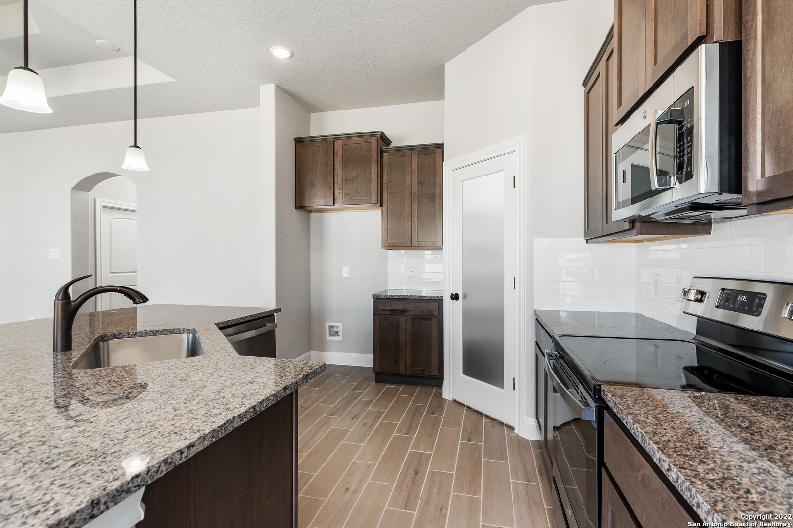 a kitchen with stainless steel appliances granite countertop a sink stove and refrigerator