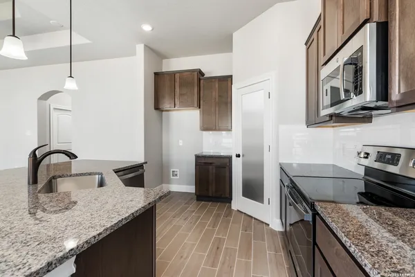 a kitchen with stainless steel appliances granite countertop a sink stove and refrigerator