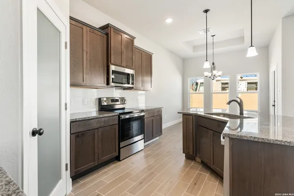 a kitchen with stainless steel appliances granite countertop a sink a stove and a refrigerator