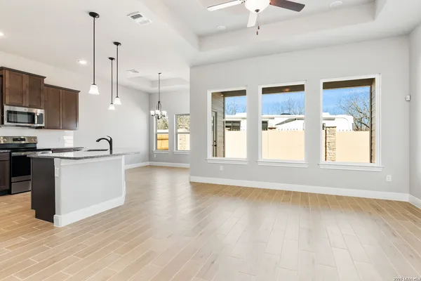 a view of large kitchen with granite countertop a stove top oven a sink a counter space and cabinets