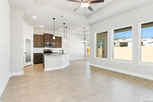 a view of kitchen with stainless steel appliances kitchen island wooden floor and window