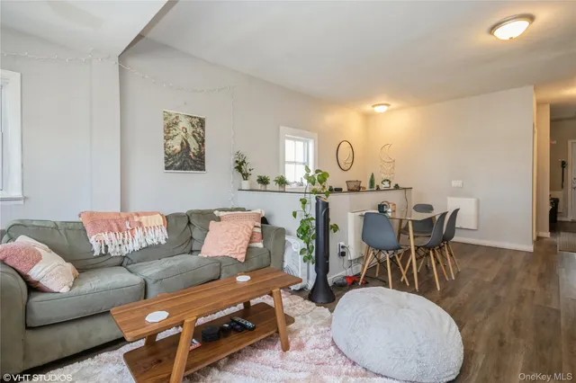 a living room with furniture a large window and dining table