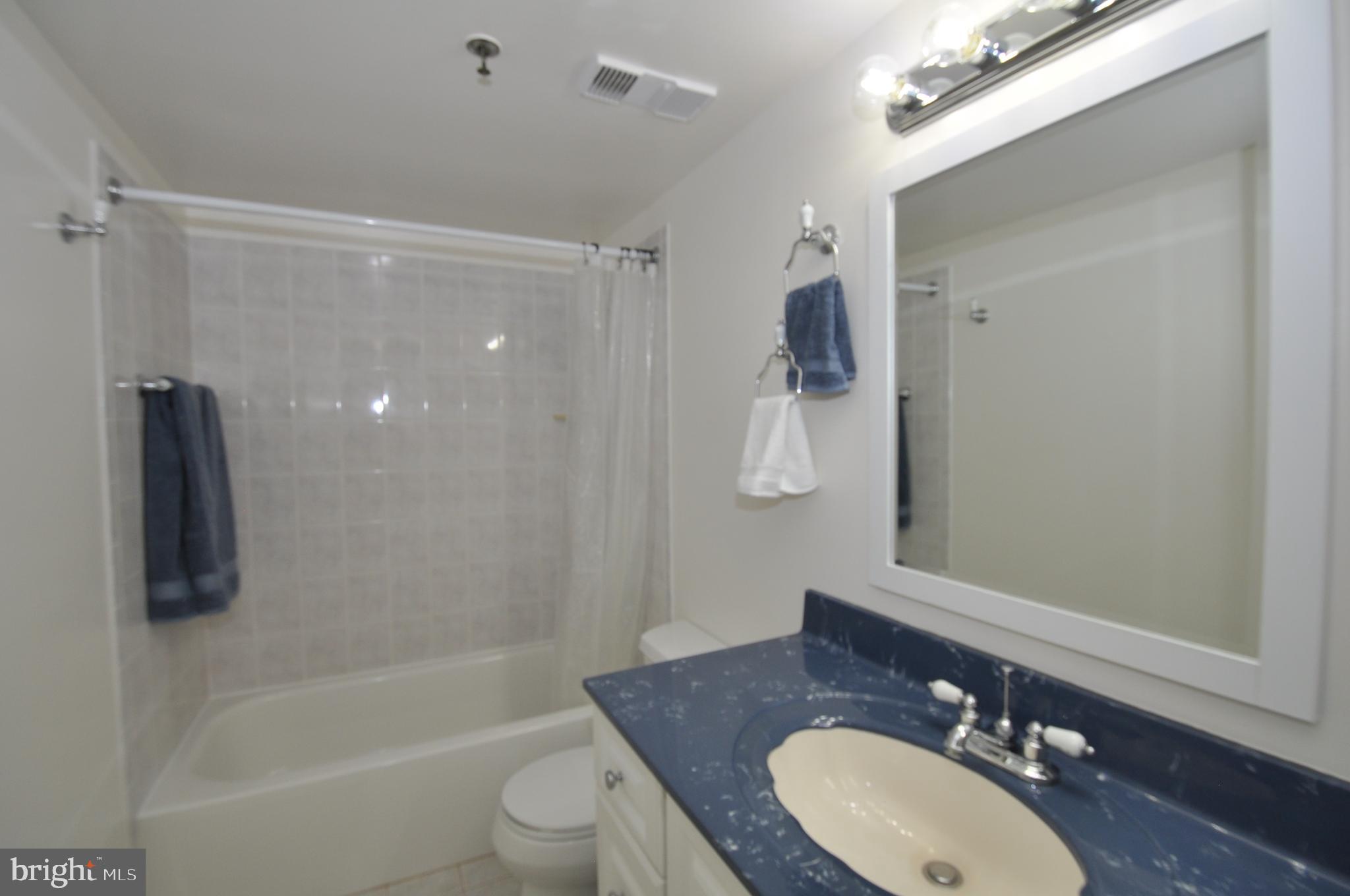 5911 Edsall Road, Unit 403 Alexandria, VA 22304 - Photo 18 of 29 a bathroom with a granite countertop sink toilet and shower