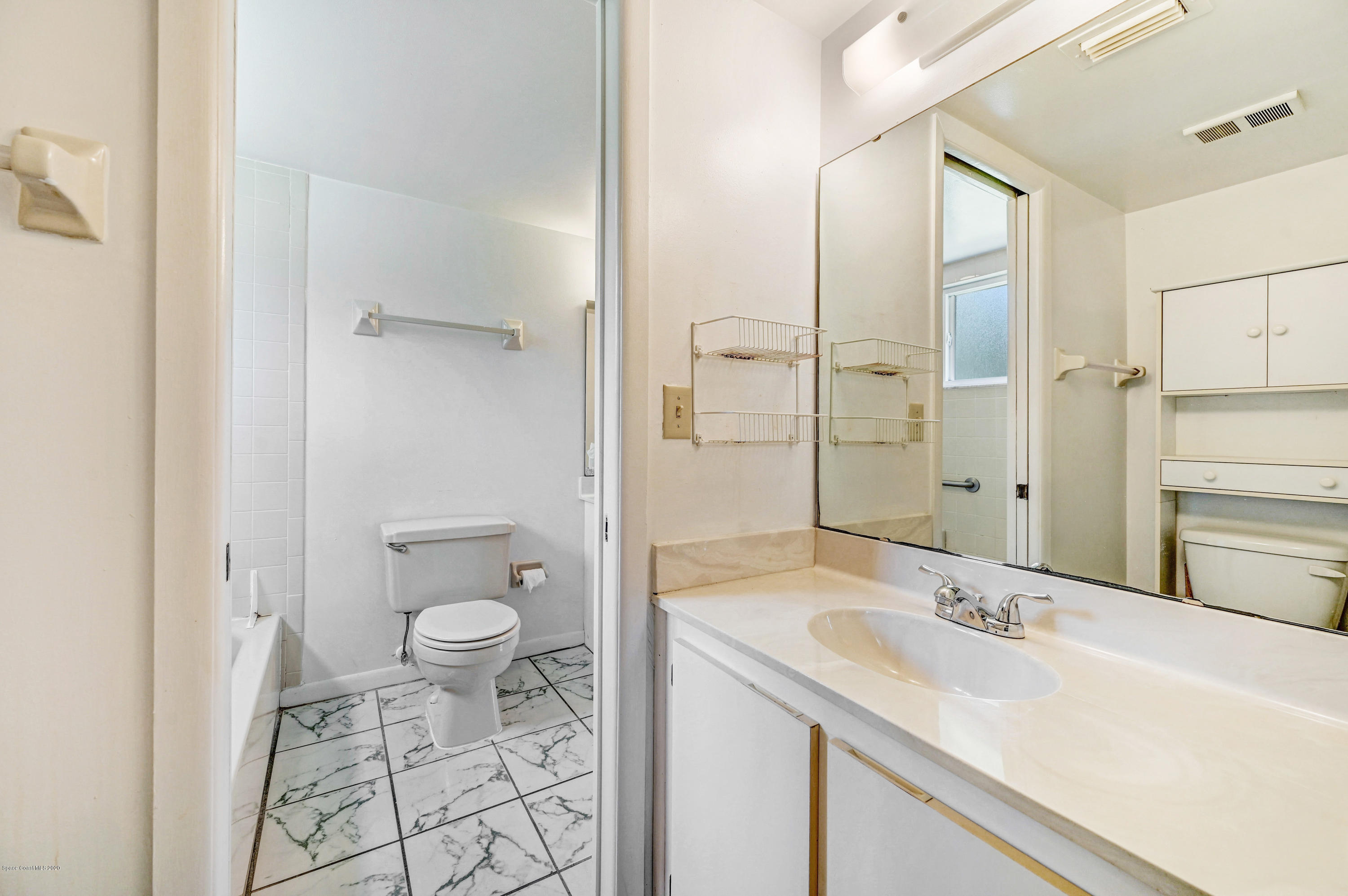 708 Ridge Club Drive, Unit 37 Melbourne, FL 32934 - Photo 13 of 25 a bathroom with a sink toilet a mirror and shower