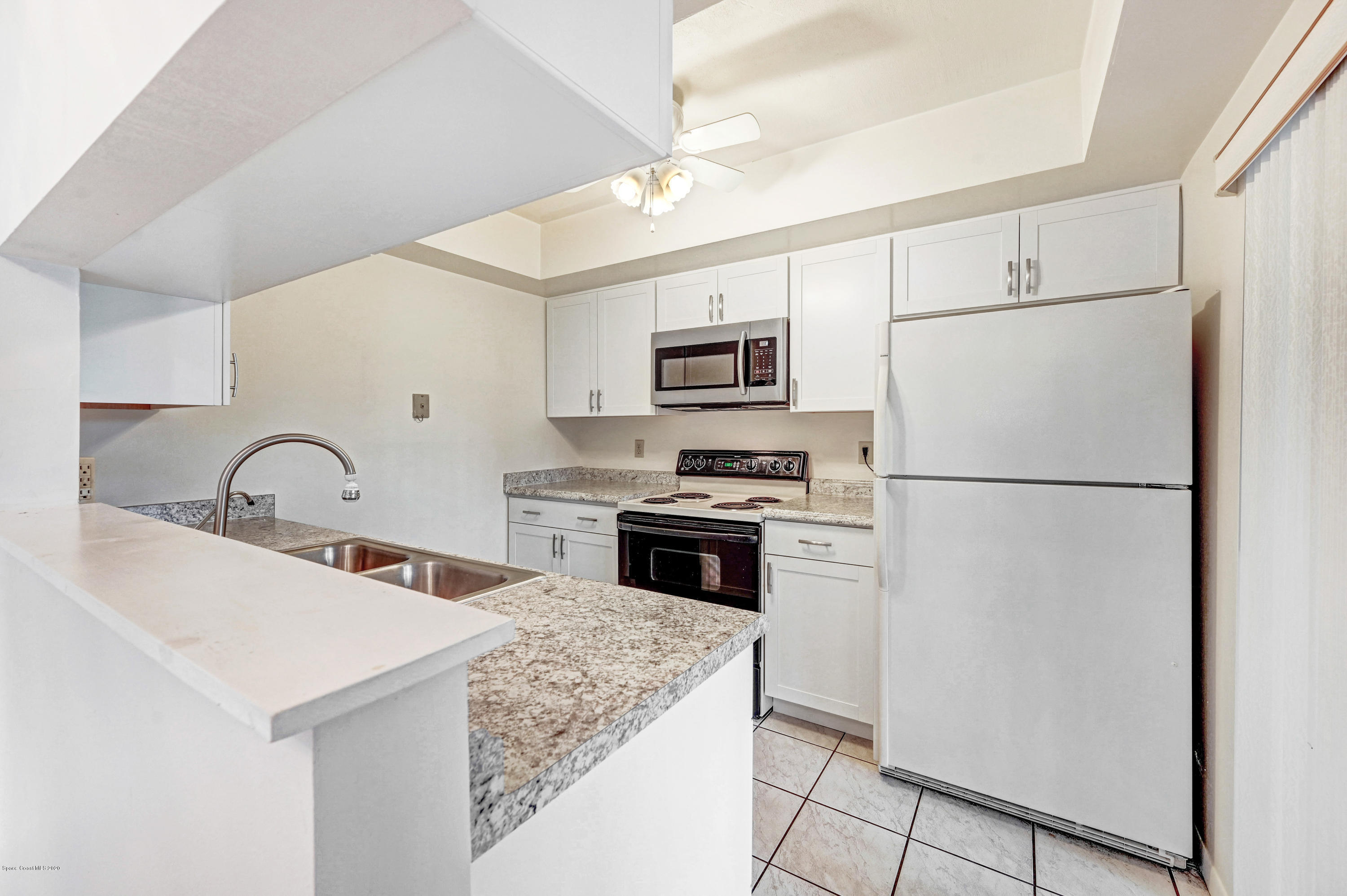 708 Ridge Club Drive, Unit 37 Melbourne, FL 32934 - Photo 9 of 25 a kitchen with stainless steel appliances a refrigerator stove and white cabinets