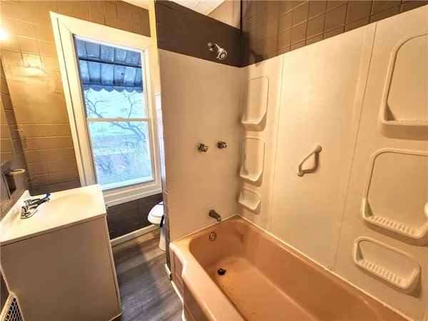 a bathroom with a tub sink and mirror