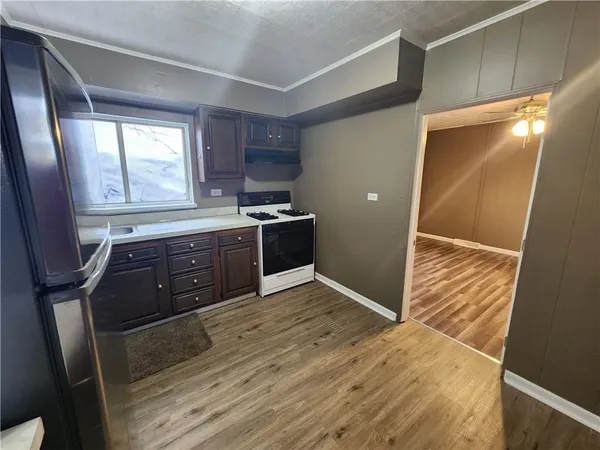 a view of kitchen with granite countertop window and wooden floor