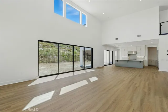 a large kitchen with stainless steel appliances a large counter top a stove and a refrigerator