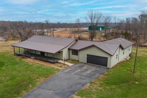 a aerial view of a house with a yard and a car park in front of the house