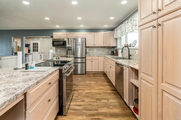 a large kitchen with stainless steel appliances lots of counter top space and cabinets