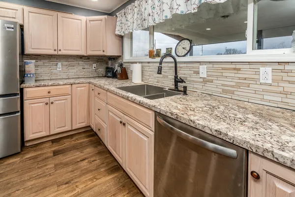 a kitchen with granite countertop a sink and cabinets