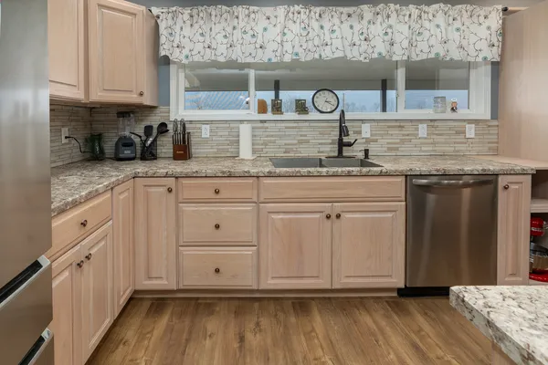 a kitchen with stainless steel appliances granite countertop a sink and cabinets