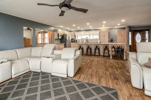 a living room with furniture a dining table and wooden floor