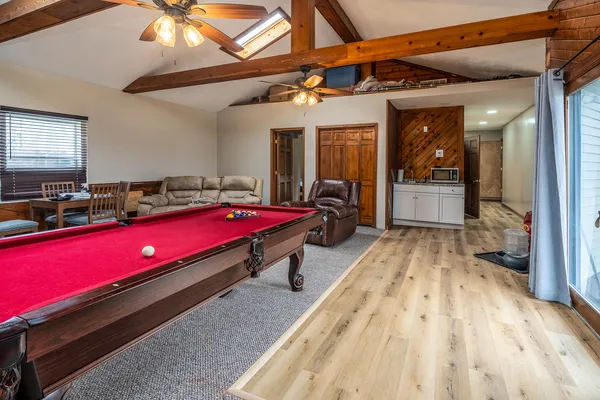 a living room with furniture a flat screen tv and kitchen view