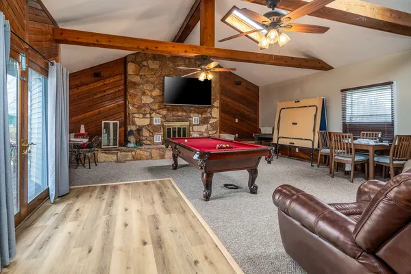 a room with pool table flat screen tv and windows