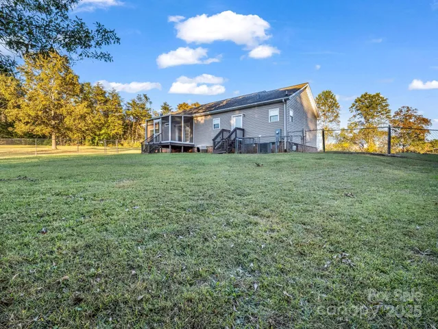 a view of a big house with a big yard and large trees