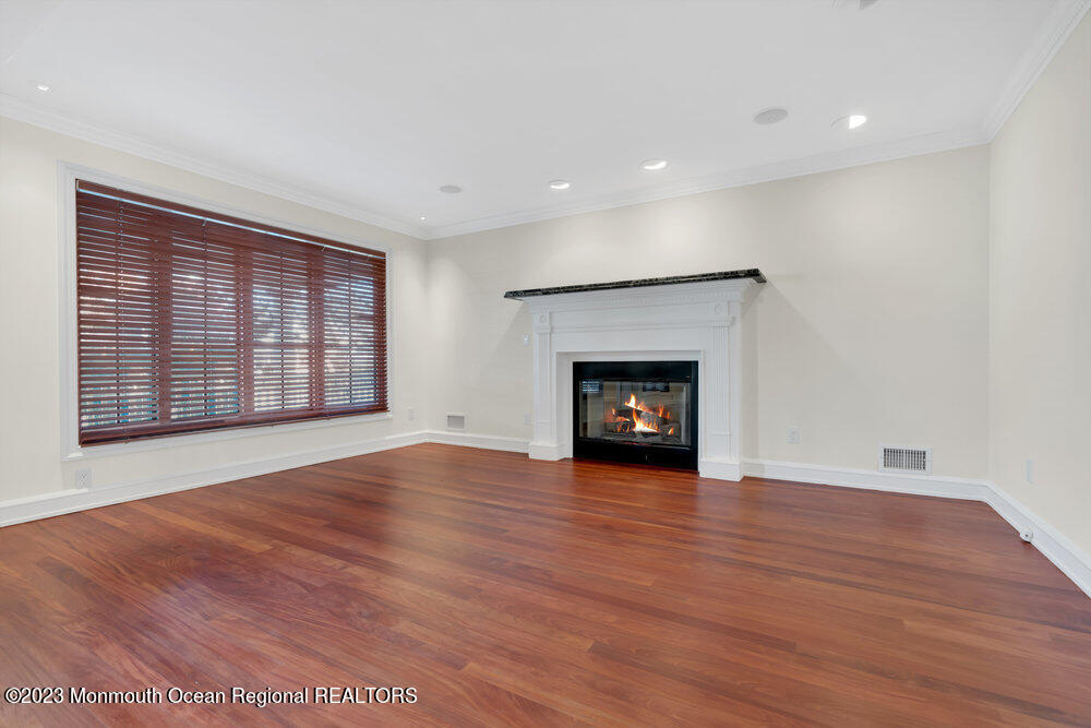 511 Passaic Avenue Spring Lake, NJ 07762 - Photo 8 of 105 an empty room with wooden floor fireplace and windows