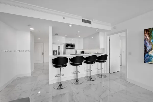 a kitchen with stainless steel appliances kitchen island granite countertop a table and chairs