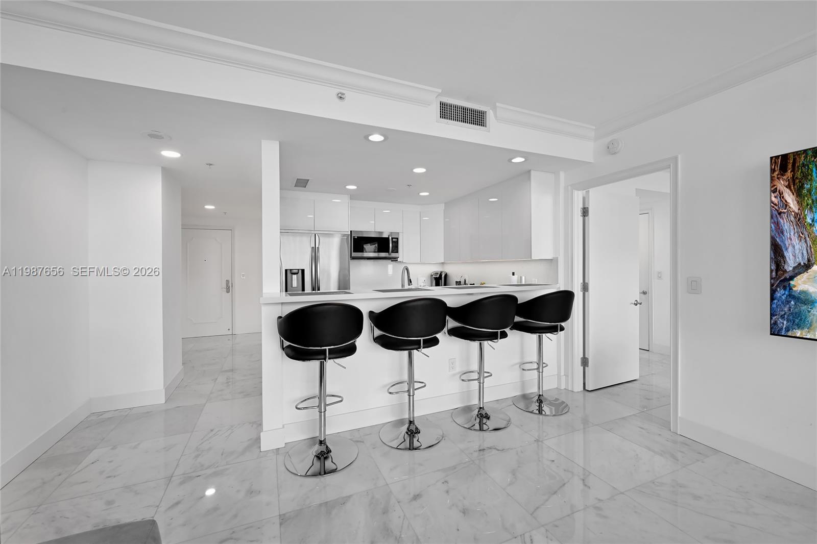 3350 Southwest 27th Avenue, Unit 1908 Coconut Grove, FL 33133 - Photo 4 of 17 a kitchen with stainless steel appliances kitchen island granite countertop a table and chairs