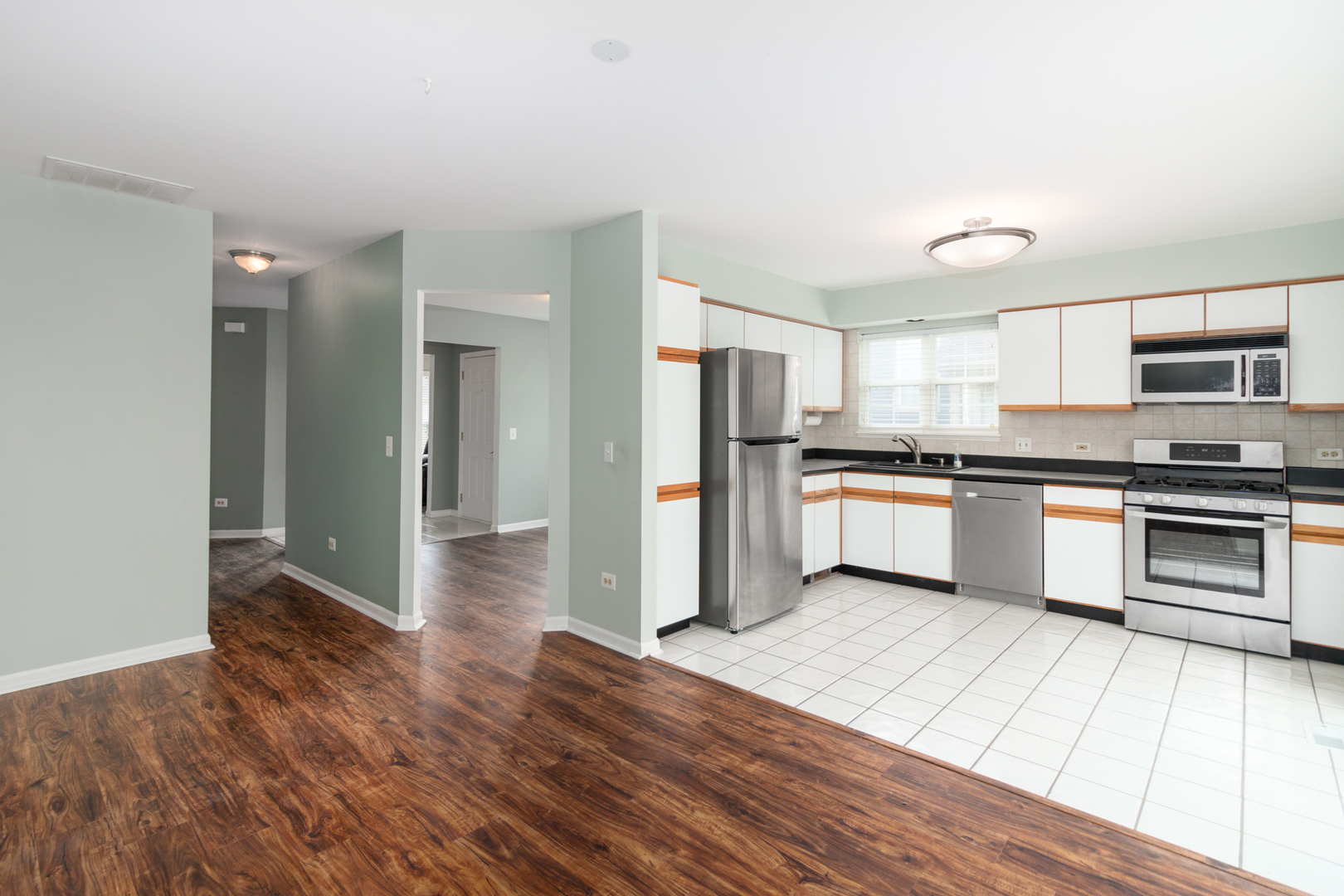1176 Coldspring Road Elgin, IL 60120 - Photo 6 of 24 a kitchen with granite countertop a refrigerator and a stove top oven
