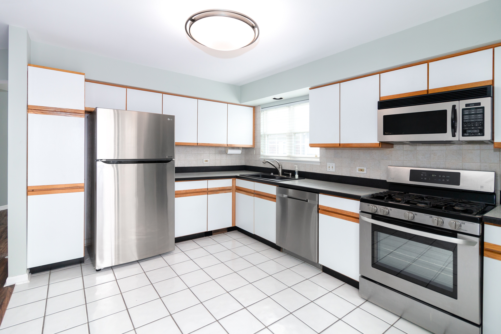 1176 Coldspring Road Elgin, IL 60120 - Photo 7 of 24 a kitchen with granite countertop a refrigerator and a stove top oven