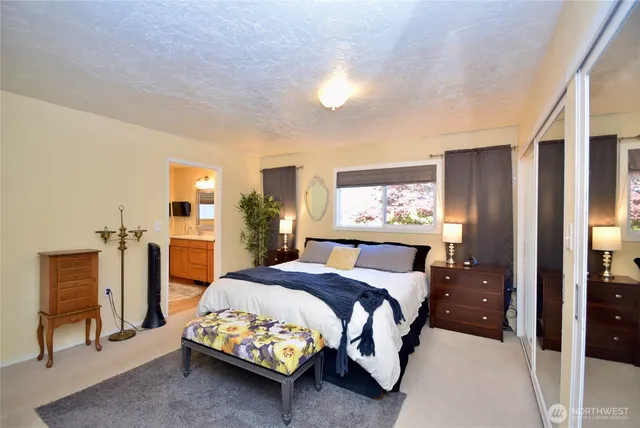 a spacious bathroom with a granite countertop sink a toilet a mirror and shower