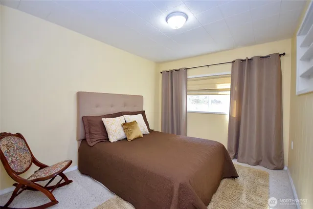 a bedroom with two beds and a large window