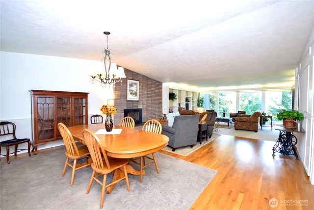 a dining room with furniture a chandelier and wooden floor