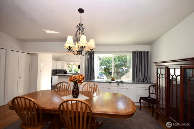 a dining room with furniture a chandelier and window
