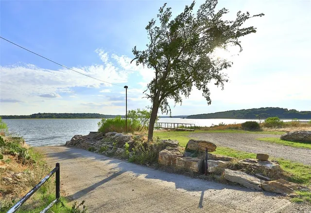 a view of a lake with lawn chairs