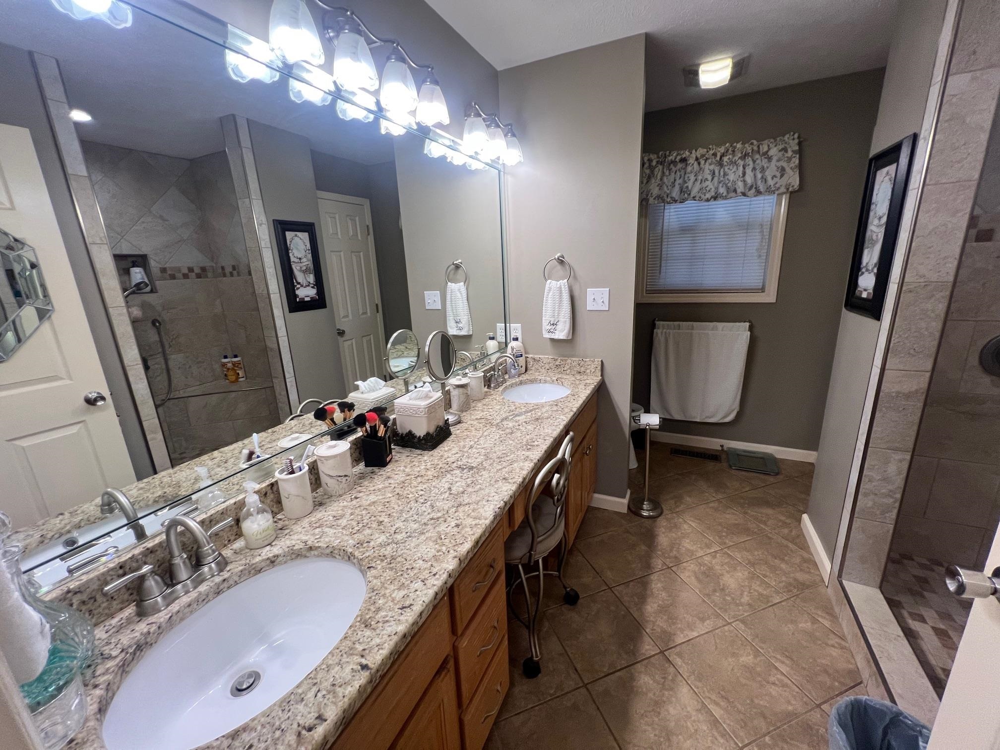 880 Double Springs Loop Savannah, TN 38372 - Photo 14 of 40 a bathroom with a granite countertop double vanity sink and a mirror