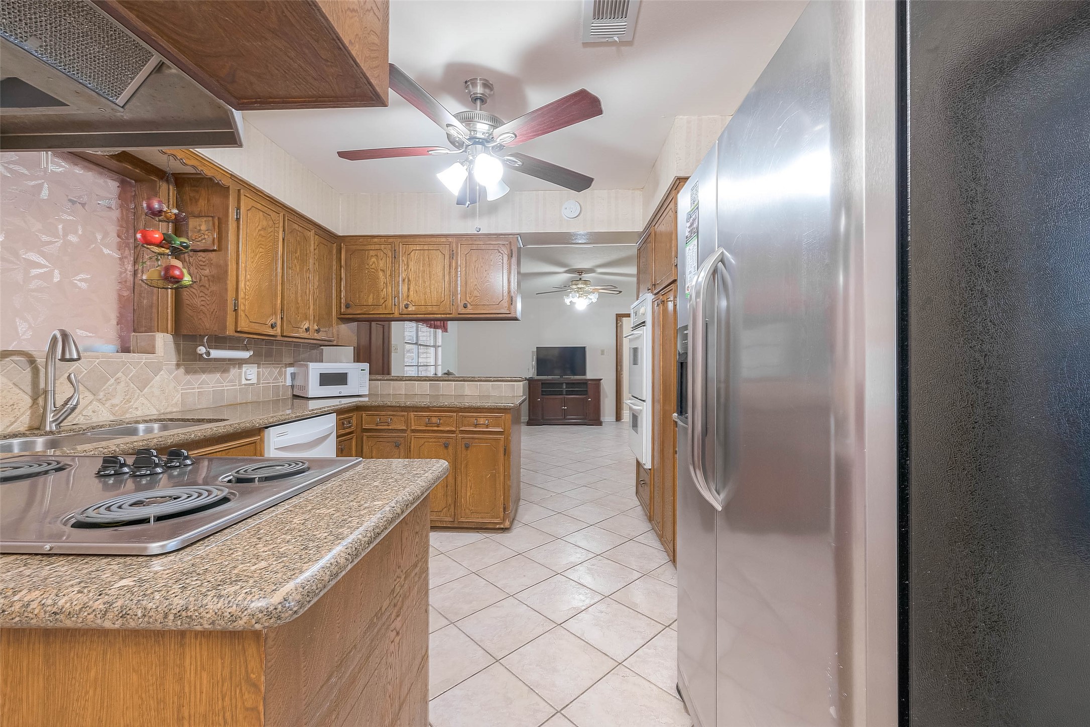 1503 Miles Street Rosenberg, TX 77471 - Photo 8 of 25 a kitchen with granite countertop a sink stainless steel appliances and cabinets