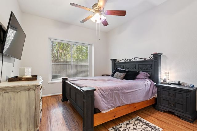 a bedroom with a bed and a flat tv screen on dresser