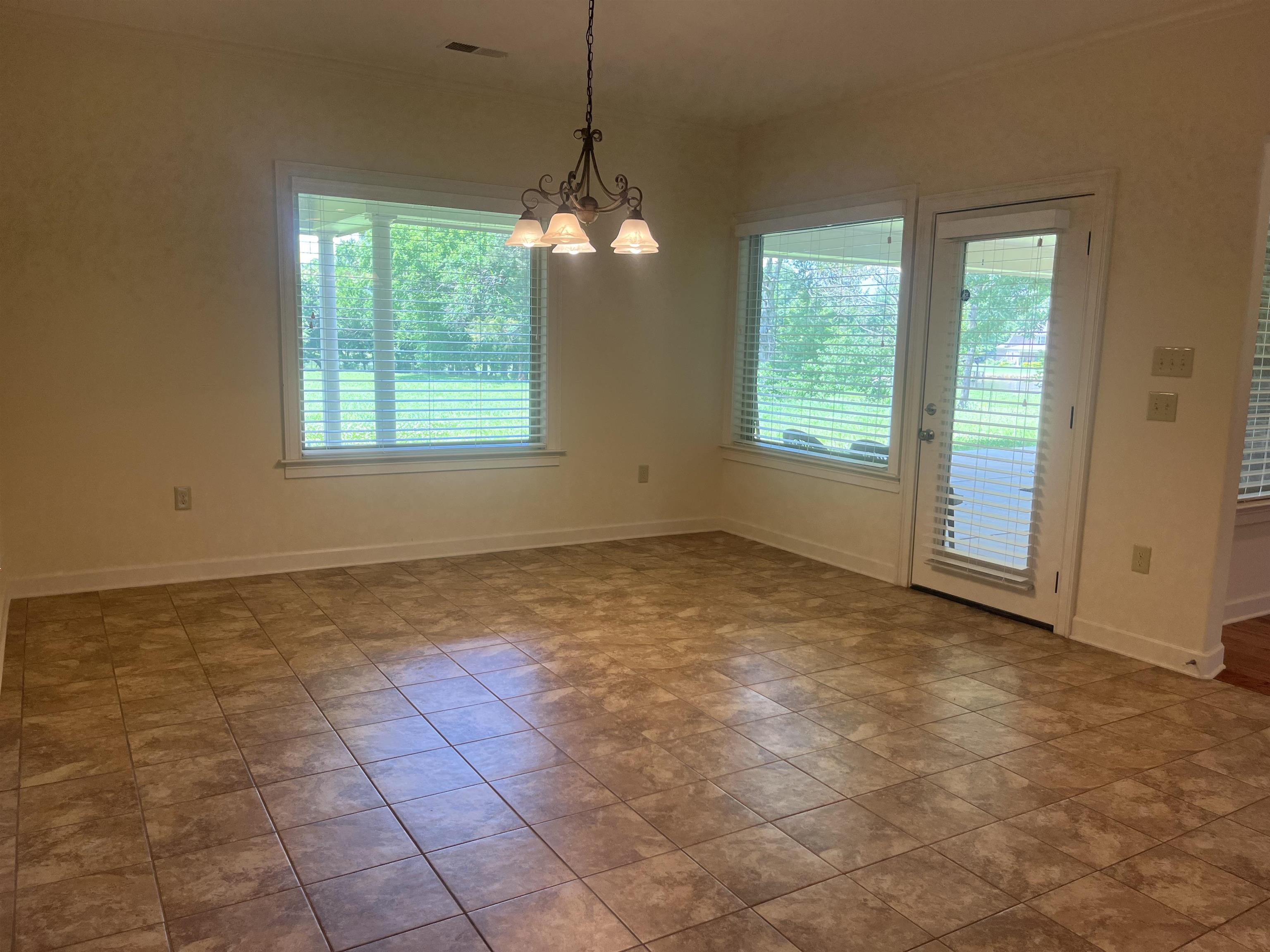 185 Belmont Road Mason, TN 38049 - Photo 31 of 40 Spacious room featuring neutral tone ceramic tile flooring, a multi-light chandelier, and large windows with blinds