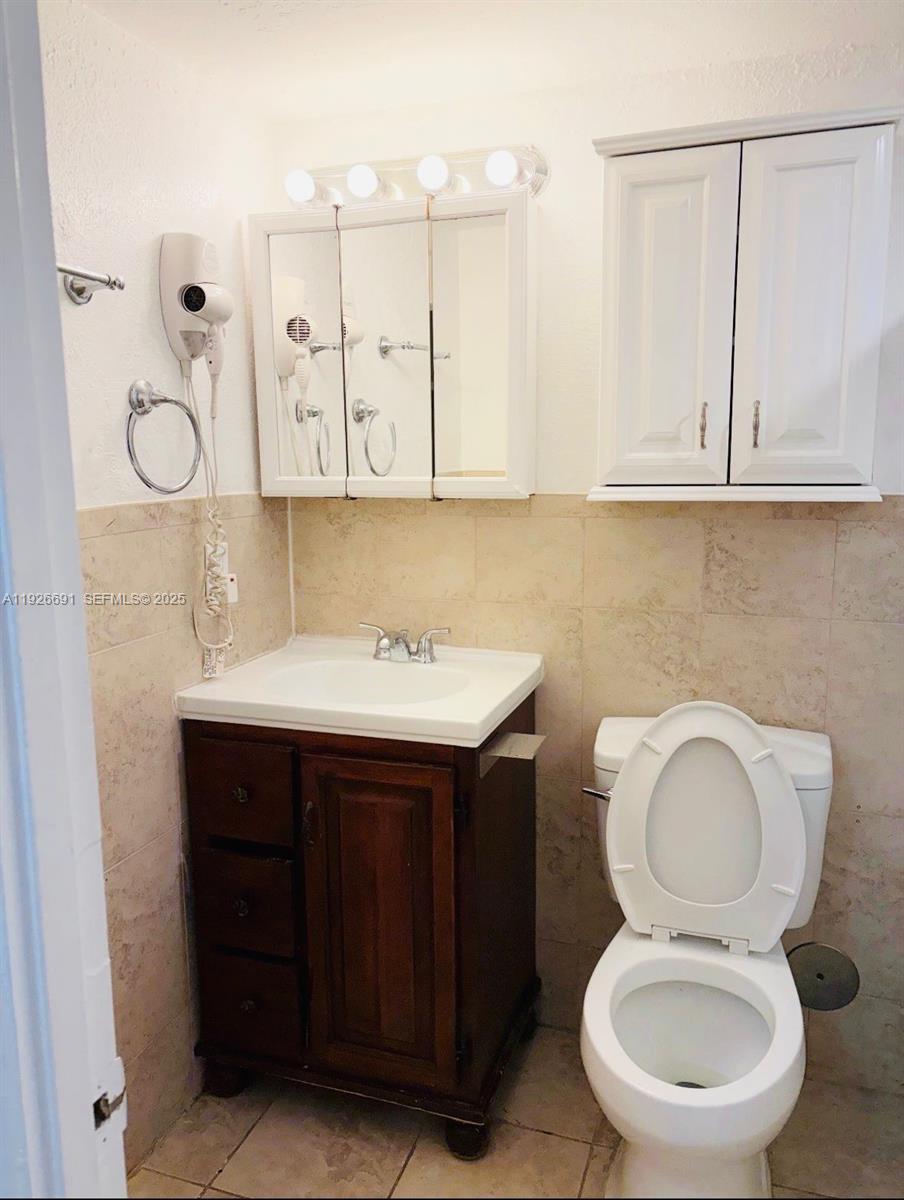 8003 West 6th Avenue, Unit B Hialeah, FL 33014 - Photo 14 of 19 a bathroom with a toilet sink and mirror