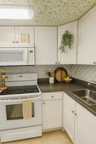 a kitchen with granite countertop white cabinets and a stove