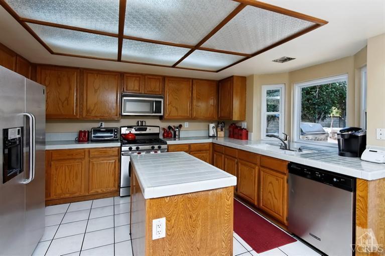 3903 Southhampton Road Moorpark, CA 93021 - Photo 11 of 29 a kitchen with stainless steel appliances wooden cabinets a sink and a stove