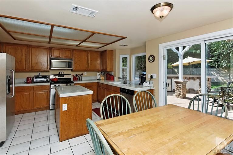 3903 Southhampton Road Moorpark, CA 93021 - Photo 13 of 29 a kitchen with granite countertop a stove a sink a dining table and chairs