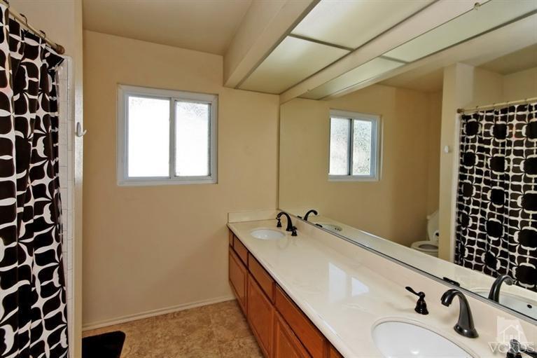 3903 Southhampton Road Moorpark, CA 93021 - Photo 19 of 29 a bathroom with a double vanity sink a mirror and a shower